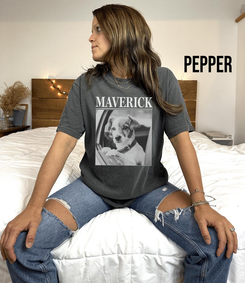 May include: Dark gray t-shirt with the word "MAVERICK" above a black and white image of a dog. The word "PEPPER" is printed in large black letters on the upper right side of the shirt.