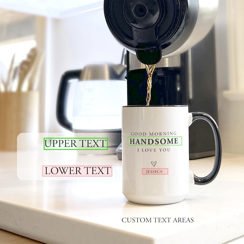 May include: A white ceramic mug with a black handle and rim, featuring the printed text GOOD MORNING HANDSOME I LOVE YOU, a small heart icon, and the name JESSICA. Coffee is being poured into the mug from a coffee maker in the background.