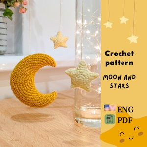 May include: Crochet pattern for a moon and stars. The pattern is available in English and is a PDF download. The image shows a yellow crocheted moon and white crocheted stars.