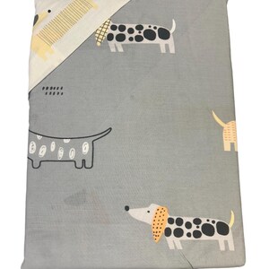 A folded duvet cover set in grey with a dachshund dog pattern