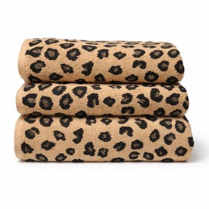 May include: A stack of three folded rectangular towels featuring a repeating black leopard print pattern on a tan background. The towels have a textured, soft appearance with finished edges and are stacked neatly one on top of the other.