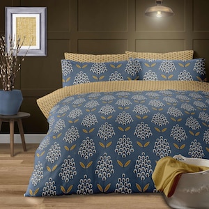 Peut inclure: Une housse de couette florale bleue et jaune avec un motif répétitif de fleurs stylisées. La housse de couette est faite d'un tissu doux et confortable et présente un léger brillant.