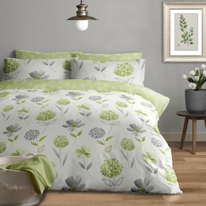 May include: White duvet cover with a green and grey floral pattern. The duvet cover is on a bed with two green and white patterned pillowcases.