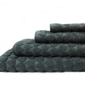 May include: Four dark teal bath towels stacked on top of each other. The towels feature a geometric, textured design. A washcloth sits on top of the pile. The towels are made from a soft, absorbent material, perfect for the bathroom.