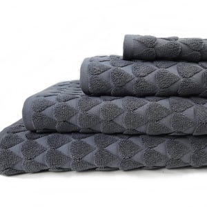 Op de afbeelding: Een stapel van vier grijze badhanddoeken. De handdoeken zijn gevouwen en op elkaar gestapeld. De handdoeken hebben een geometrisch ruitpatroon. De handdoeken zijn gemaakt van een zacht, absorberend materiaal.