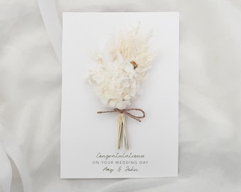 May include: White wedding card with a dried flower bouquet and the text "Congratulations on your wedding day Amy & John"