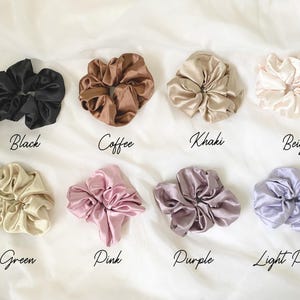 May include: Assortment of ten satin scrunchies in various colors, including black, coffee, khaki, beige, green, pink, purple, and light purple.