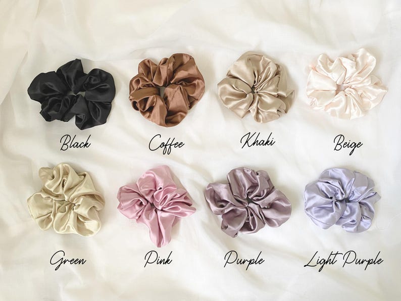May include: Assortment of ten satin scrunchies in various colors, including black, coffee, khaki, beige, green, pink, purple, and light purple.