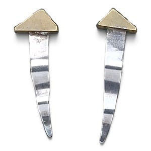 May include: A pair of earrings featuring a triangular gold-toned top section attached to a long, slender, hammered silver-toned drop. The silver component has a slightly curved, tapered shape with a textured, reflective surface finish throughout.