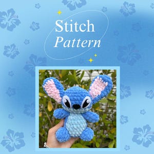 Peut inclure: Un jouet en peluche Stitch crocheté bleu et bleu clair avec des oreilles roses. Le jouet est tenu dans une main sur un fond de verdure.