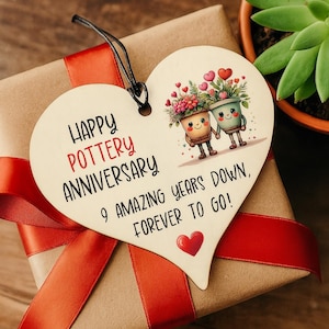 Pode incluir: Uma caneca de cerâmica branca com uma alça preta e o texto "But First, Coffee" em preto, em negrito. A caneca está sobre uma superfície de madeira. A caneca tem aproximadamente 10 cm de altura.