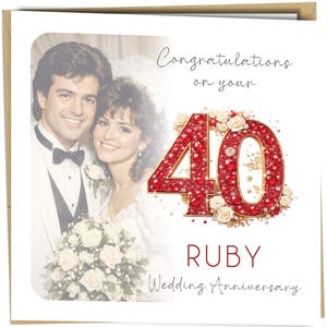 May include: A wedding anniversary card with a photo of a smiling couple. The card reads "Congratulations on your 40 Ruby Wedding Anniversary" in elegant script. The number 40 is in a red jeweled font, surrounded by white roses.