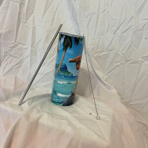 K&ouml;nnte beinhalten: Ein Edelstahlbecher mit einem tropischen Inselmotiv. Der Becher wird mit einem Edelstahlstrohhalm und einer Reinigungsb&uuml;rste geliefert.