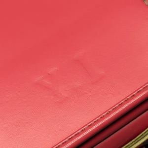 May include: Close-up of a red leather bag with the word "YETI" embossed on the front.
