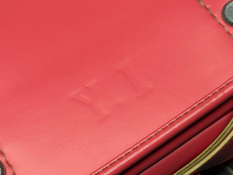 May include: Close-up of a red leather bag with the word "YETI" embossed on the front.