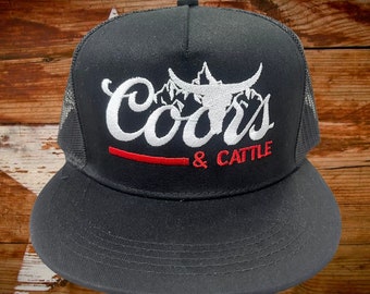 Gorra Western Mountains & Cattle: gorra de camionero negra con bordados llamativos en blanco y rojo