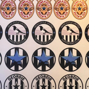 May include: A set of 10 round stickers featuring Newcastle United Football Club logos. The stickers feature the team's colors of black and white, with a magpie bird, a star, and the words "Newcastle United Supporters Club". There are also stickers with the words "The One and Only Newcastle Brown Ale" and "Geordie and Proud".
