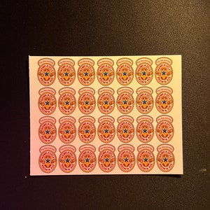 May include: A sheet of 36 stickers featuring the Newcastle Brown Ale logo. Each sticker is round and features a brown ale bottle with a red and white label that says "The One and Only Newcastle Brown Ale".