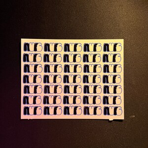 May include: A sheet of white sticker paper with a repeating pattern of the word "NUG" in black and white with a blue outline.