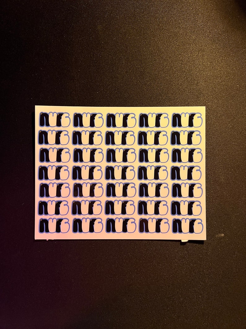 May include: A sheet of white sticker paper with a repeating pattern of the word "NUG" in black and white with a blue outline.