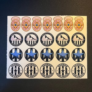 May include: A sheet of stickers featuring Newcastle United Football Club logos. The stickers are black and white with a blue star and a magpie. The text on the stickers reads "Newcastle United Supporters Club" and "Geordie and Proud".
