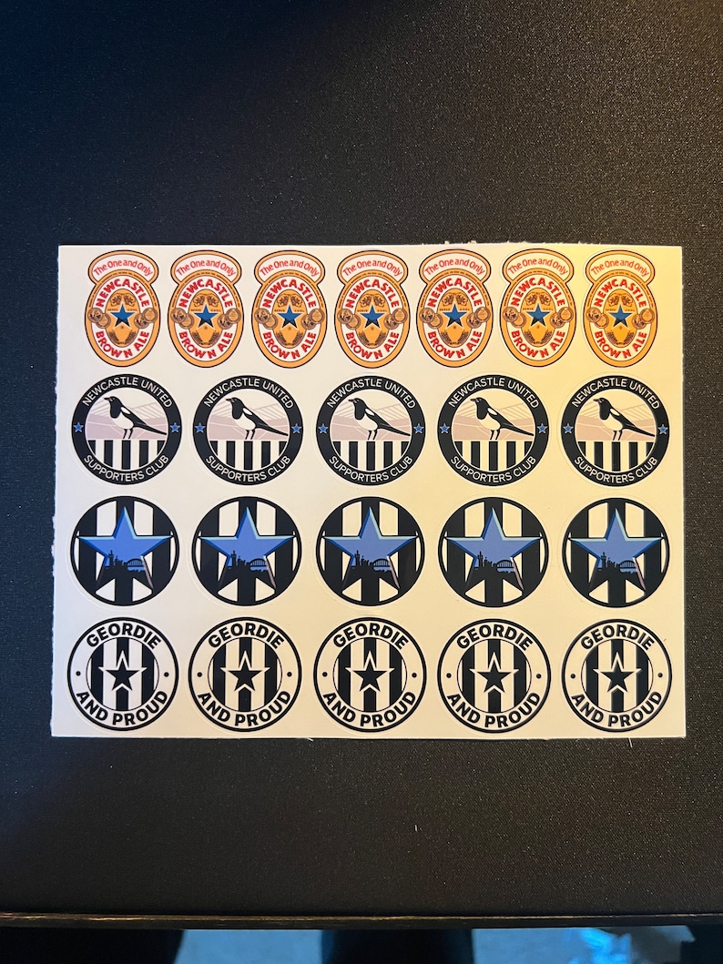 May include: A sheet of stickers featuring Newcastle United Football Club logos. The stickers are black and white with a blue star and a magpie. The text on the stickers reads "Newcastle United Supporters Club" and "Geordie and Proud".