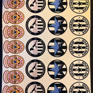 May include: A sheet of stickers featuring Newcastle United and Geordie football club logos. The stickers are black, white, and blue with a star and magpie design. The text on the stickers reads "Newcastle United Supporters Club" and "Geordie And Proud".