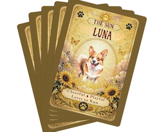 Può includere: Un ventaglio di carte rettangolari con bordo dorato. La carta superiore presenta un'illustrazione di un Corgi, il testo THE SUN LUNA e le parole Cheerful, Playful, Loves to Run. Il design include girasoli, farfalle e icone di impronte.