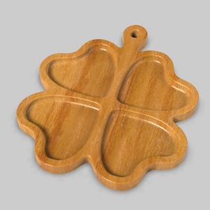 May include: A wooden serving tray shaped like a four-leaf clover with four separate compartments. The tray is made of light brown wood and has a smooth, polished finish.