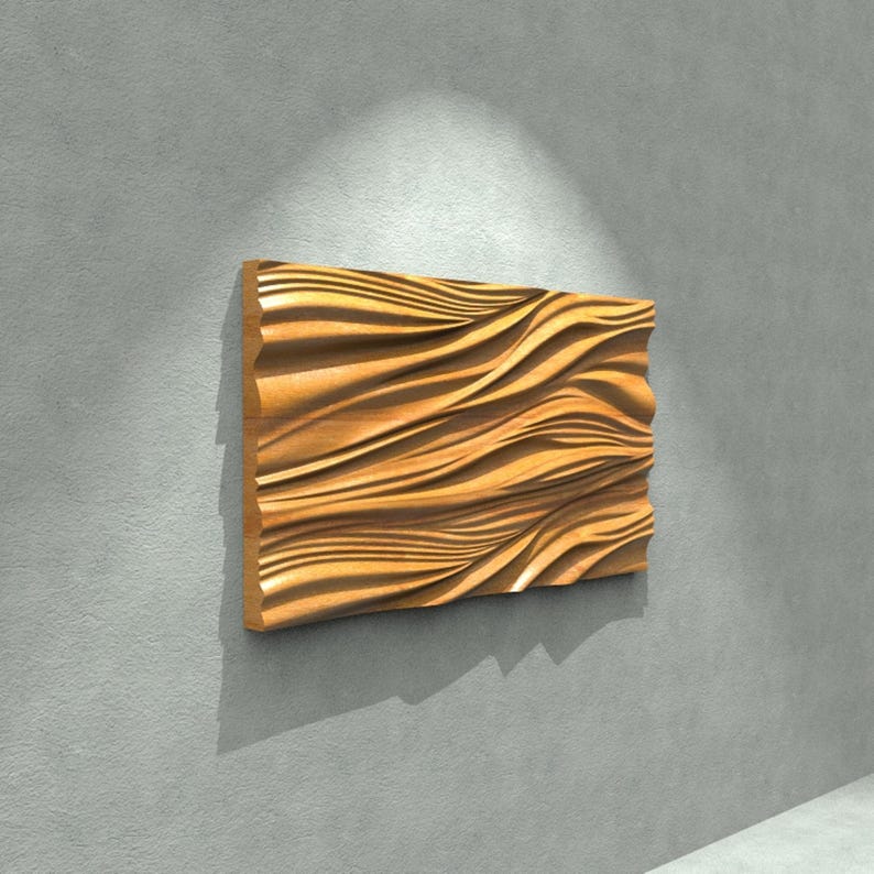 May include: A rectangular wooden wall art piece with a wave-like pattern carved into its surface. The artwork is a warm, natural wood tone, mounted on a gray wall. The piece is illuminated by a spotlight, creating shadows that emphasize the texture.