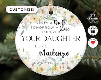 May include: White ceramic ornament with a floral design and the text "Today a Bride, Tomorrow a Wife, Forever Your Daughter Love, Mackenzie January 15, 2026".