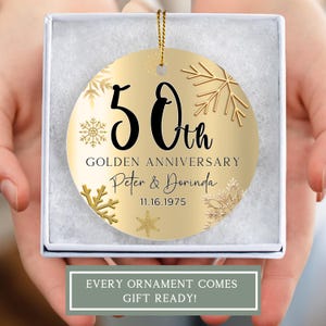 May include: Gold round ornament with a snowflake design. It says "50th Golden Anniversary Peter & Dorinda 11.16.1975"