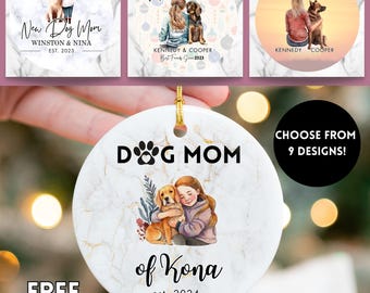 Può includere: Ornamento rotondo in ceramica bianca con un design marmorizzato dorato, raffigurante una persona e un cane. Il testo "DOG MOM of Kona est. 2024" è visibile. L'immagine mostra anche altri modelli di ornamenti.