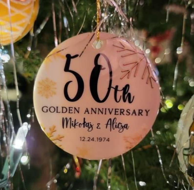 May include: A pink and gold round Christmas ornament with the text "50th Golden Anniversary Mikołaj & Alicja 12.24.1974".