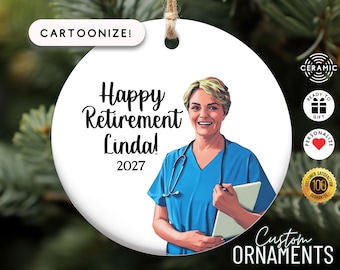 May include: A white ceramic ornament with a cartoon illustration of a smiling woman in blue scrubs, a stethoscope, and a tablet. The text reads "Happy Retirement Linda! 2027". The ornament is personalized and ready to gift.