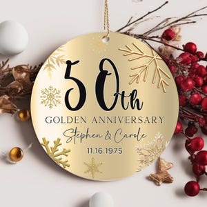May include: Gold round ornament with a gold background and snowflakes. The ornament says "50th Golden Anniversary Stephen & Carole 11.16.1975"