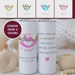 May include: White insulated tumbler with the text "Baby Robinson is Brewing" in pink and gold, with "Coming Soon 03.15.23". The other tumbler has the text "Don't rush me, I'm pregnant and this is neither coffee nor alcohol".