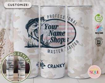 Può includere: Un bicchiere isolato bianco con un motivo mimetico e un tema di pesca. Il bicchiere presenta una grafica di pesce che salta e il testo "PROFESSIONAL Your Name Shop MASTER BAITER CRANKY". Include icone "BPA FREE" e "caldo e freddo".