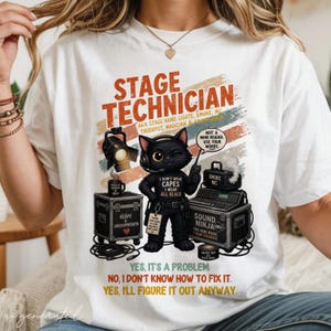 May include: A white t-shirt featuring a graphic of a black cat dressed as a stage technician. The text reads STAGE TECHNICIAN, AKA STAGE HAND, LIGHTS, SMOKE, MC, THERAPIST, MAGICIAN & SOUND NINJA, NOT A MIND READER, USE YOUR WORDS, and more.