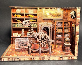 May include: A detailed wooden diorama of a dinosaur museum. The scene includes a T-Rex skeleton, display cases with fossils, and a painting of dinosaurs. The museum is lit with small lights and has a brick wall background.