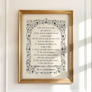 May include: A framed print displaying the Ten Commandments. The black text is set against an off-white backdrop, framed by an elaborate black border. The gold-coloured frame enhances the classic aesthetic of this religious artwork.