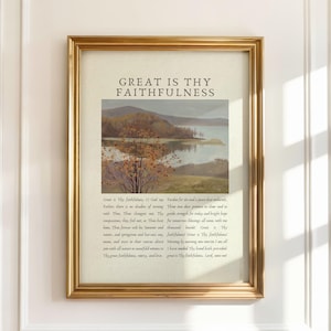 May include: A framed print with a gold-colored frame. The print features a landscape painting of a lake and mountains, with text that reads "GREAT IS THY FAITHFULNESS" at the top. The print also includes additional text below the landscape.