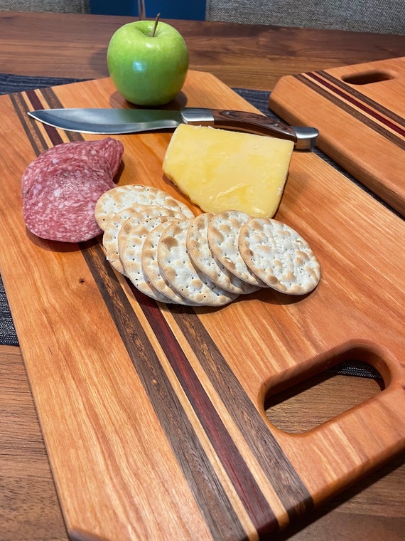Customizable Cherry Charcuterie Board with Padauk, Walnut, and Zebrawood accents.
