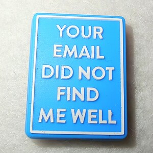 May include: A rectangular, light blue badge with a white border. The text "YOUR EMAIL DID NOT FIND ME WELL" is printed in white, centered on the badge. The badge is slightly angled, with a simple, clean design.