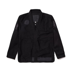 May include: Black Jiu-Jitsu Gi with embroidered patches on the sleeves and chest. The Gi has a traditional design with a collar and a belt.