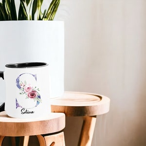 White ceramic mug with floral pattern and custom name inscription, ideal for gifting on occasions like Mother's Day or birthdays