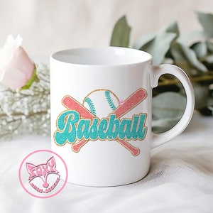 May include: White ceramic coffee mug with a teal and pink baseball graphic and the word "Baseball" in a teal and gold font.
