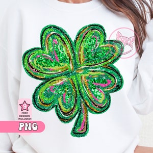 May include: A green four-leaf clover with gold and pink glitter accents. The clover is outlined in black and has a swirl design.