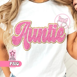 May include: A white t-shirt with a pink and gold glitter design that says "Auntie".