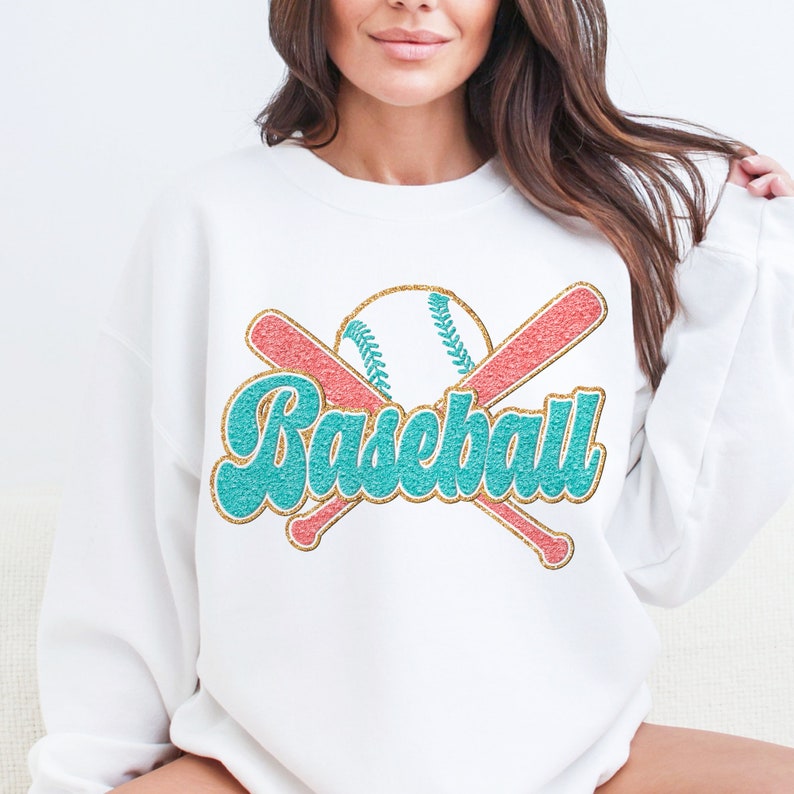 May include: White sweatshirt with a turquoise and gold glitter design of crossed baseball bats and a baseball with the word "Baseball" in turquoise glitter.